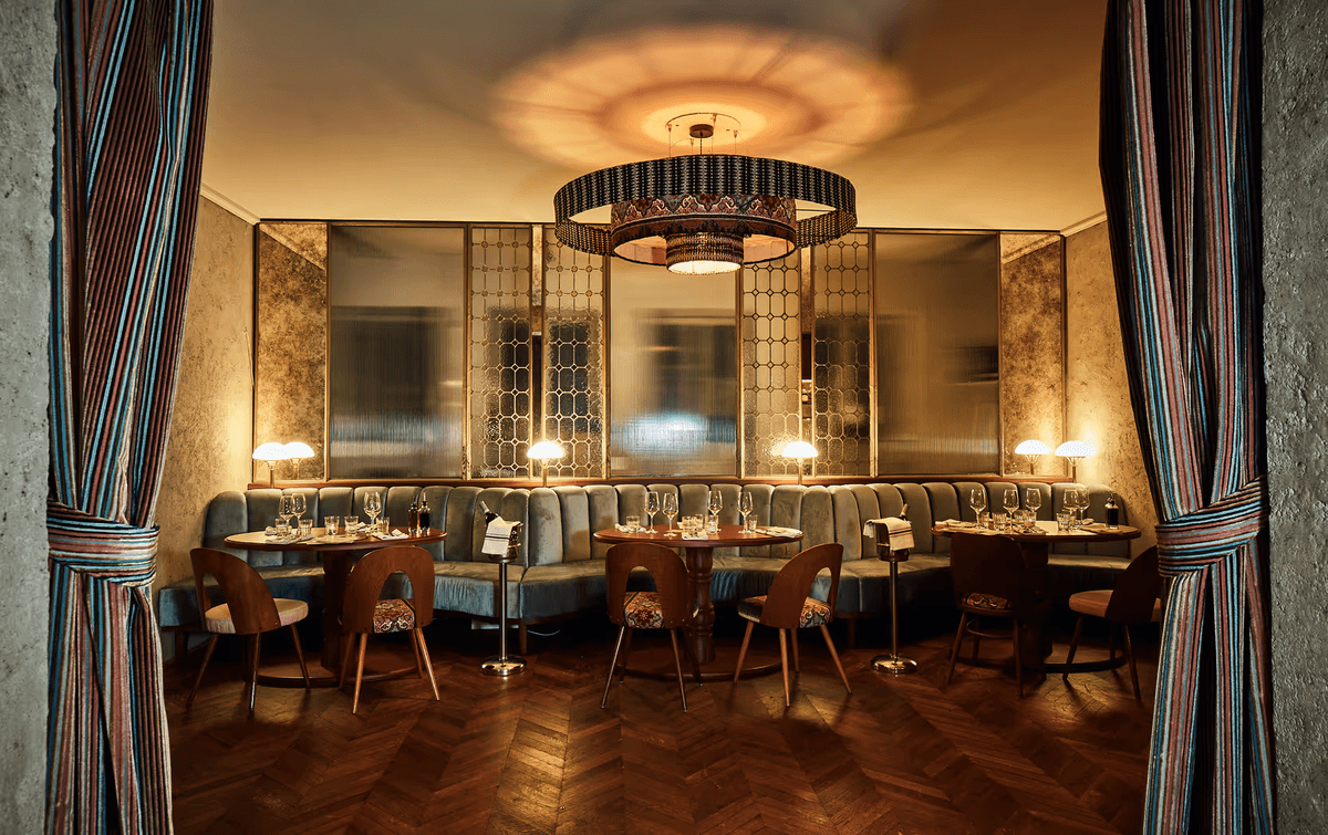 Das Separee Citronella im GIGI Restaurant: stilvoller Raum mit floraler Zitronen-Decke, warmem Licht, rosafarbenem Samtsofa und eleganter Atmosphäre für private Dinner.