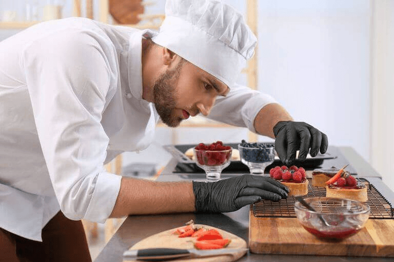 Barkeeper der Taj Mahal Trattoria beim Mixen eines Drinks – Eiswürfel fliegen durch die Luft, während er mit dem Shaker arbeitet – Actionmoment an der Bar.