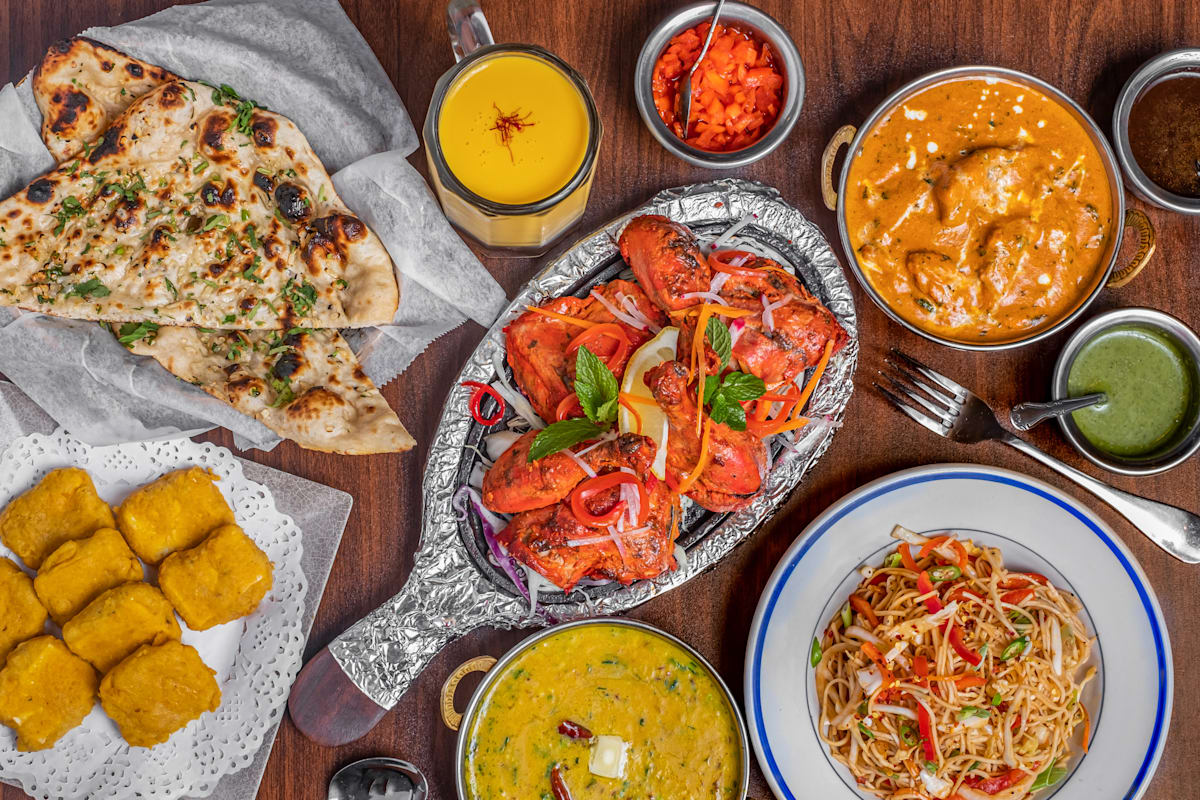 Das Separee ‚Private Dining Galerie' im Taj Mahal Restaurant: exklusiver Raum mit großem Holztisch, stimmungsvoller Beleuchtung, tropischen Pflanzen und kunstvoller Wandgestaltung – ideal für private Feiern und Dinner in elegantem Rahmen.