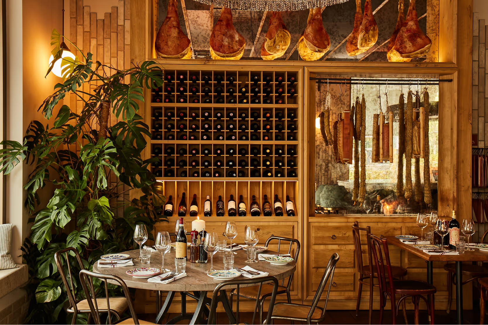 Blick von oben auf den stilvollen Barbereich der Taj Mahal Trattoria in München mit marmorierter Theke, eleganten Retro-Lampen und gemütlichen Sitznischen – italienisches Flair trifft auf modernes Interior-Design.